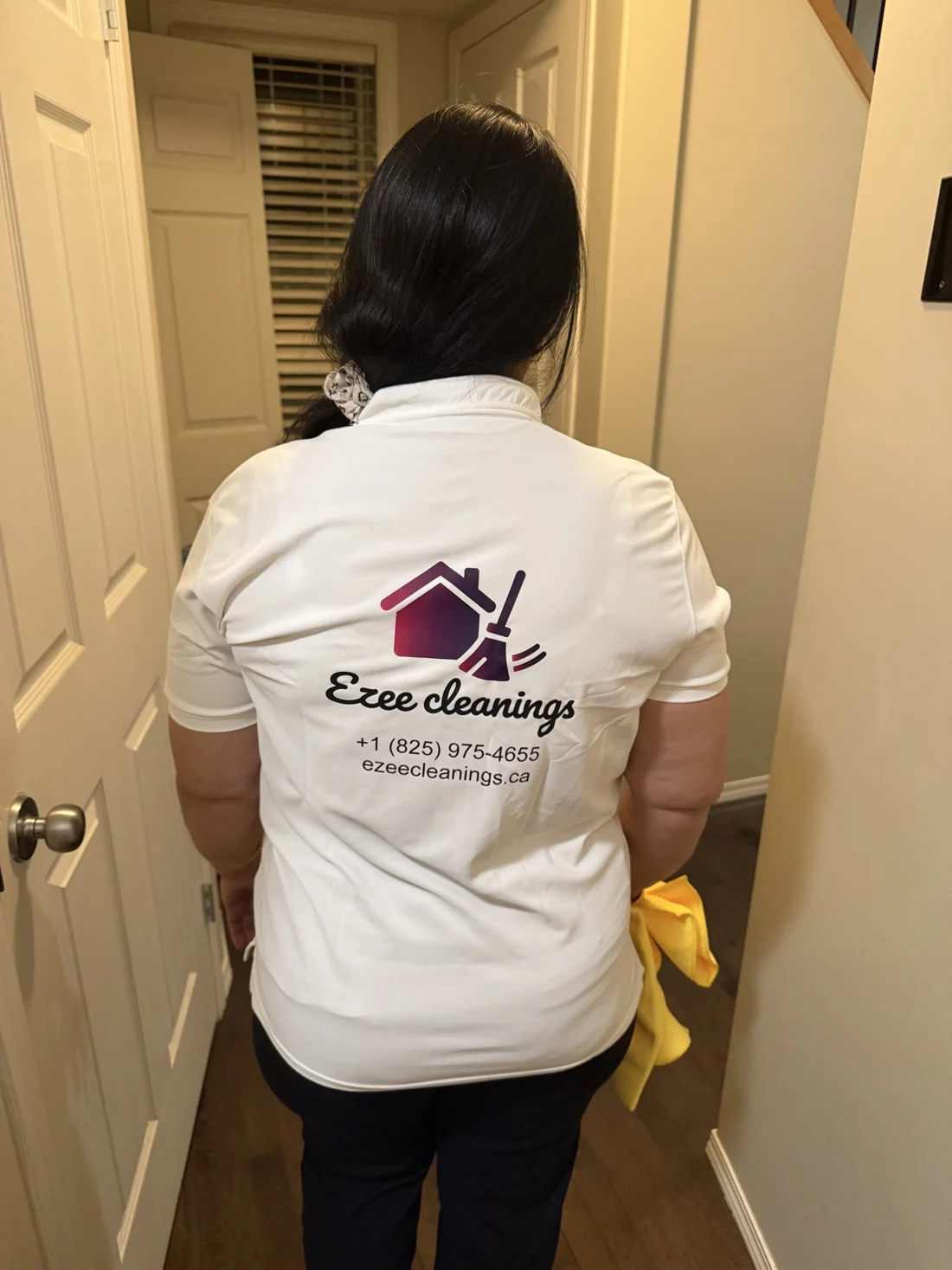 Suman Garg in her Ezee Cleanings uniform walking into a cleaning job in an Edmonton home