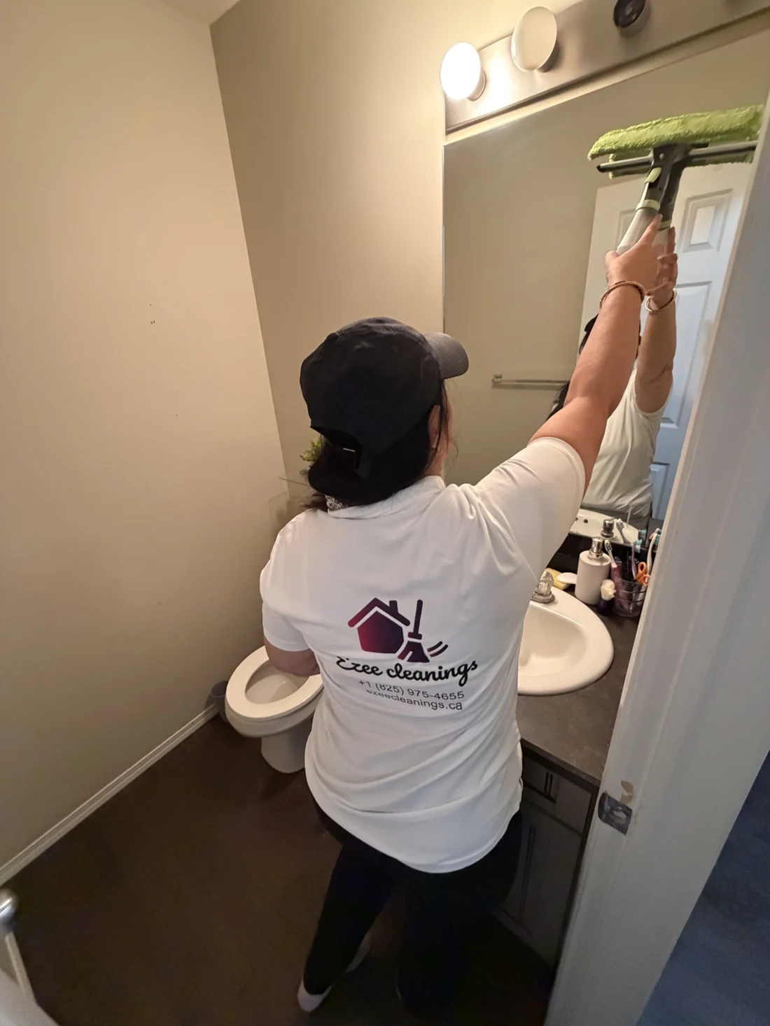 Suman Garg cleaning a bathroom mirror during an Ezee Cleanings visit