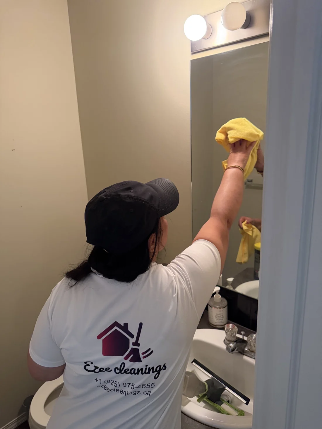 Suman Garg polishing a bathroom mirror to a shine